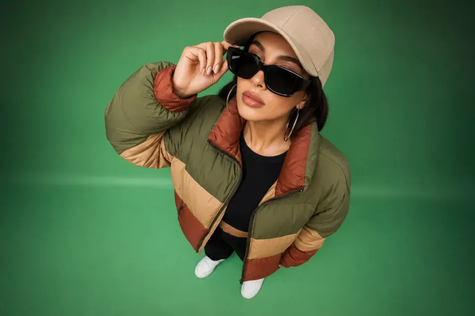 Højvinklet streetwear-portræt med grøn studiegradient